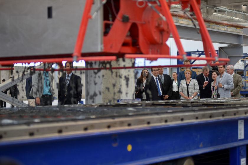 Bachelet y su equipo presencian el funcionamiento de la impresora 3D que hace casas de hormigón.